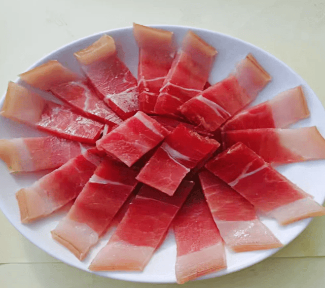 盐腌猪腿修成琵琶形坯，风晒经年凝蓄腊味醇香