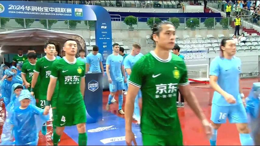 雨势不小，深圳和国安球员入场时，身旁球童都身着雨衣