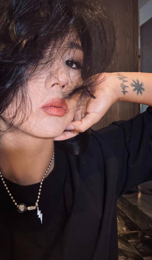 当何洁摆手进行造型时,她的纹身图案也在镜中显眼可见.