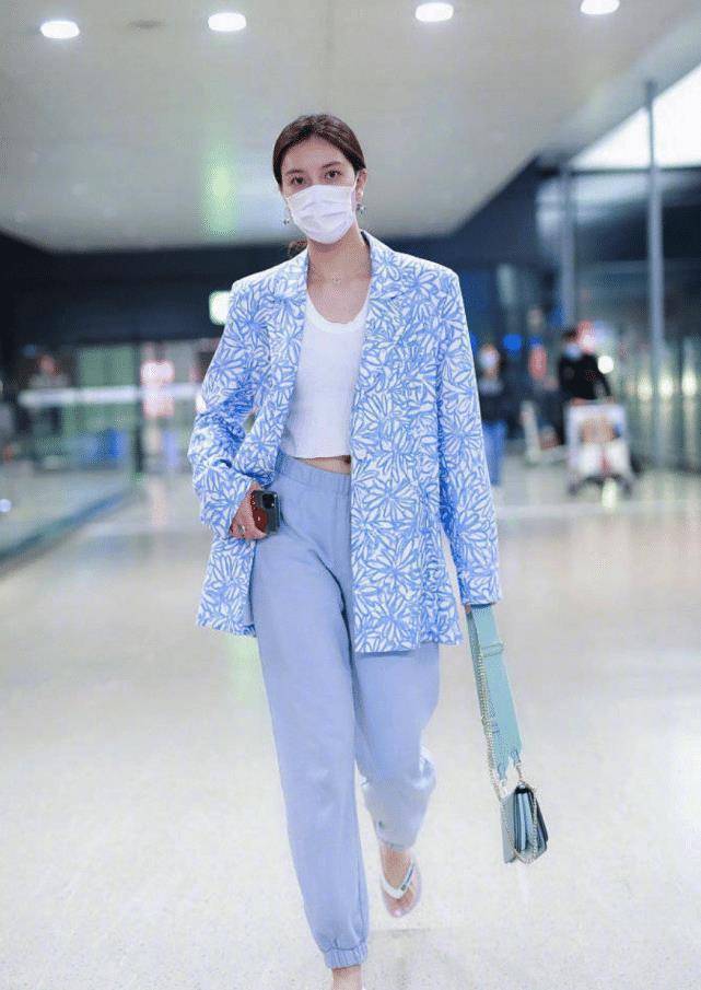 身穿圆领短款白色单衣,搭配浅蓝色系印花西装,下身是同色系窄脚休闲裤