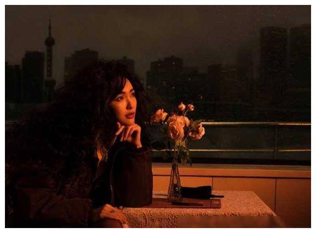 展露出那修长秀美的美腿,锁骨深邃,颈项修长,爆炸头卷发和精致的妆容
