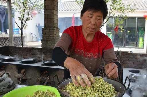 四月正是吃槐花的季节,在河南郏县安良镇,今年62岁的张大妈正在灶台前