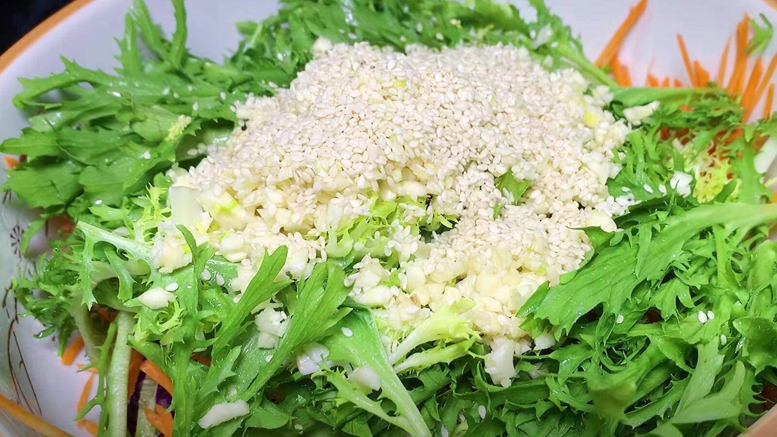 5,下一步往里加入黄瓜丝,胡萝卜丝,苦菊菜,再往里倒入提前切好的蒜末