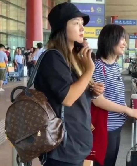 原创33岁何洁背1万5的包包现身机场短t搭配短裤小肚腩一言难尽