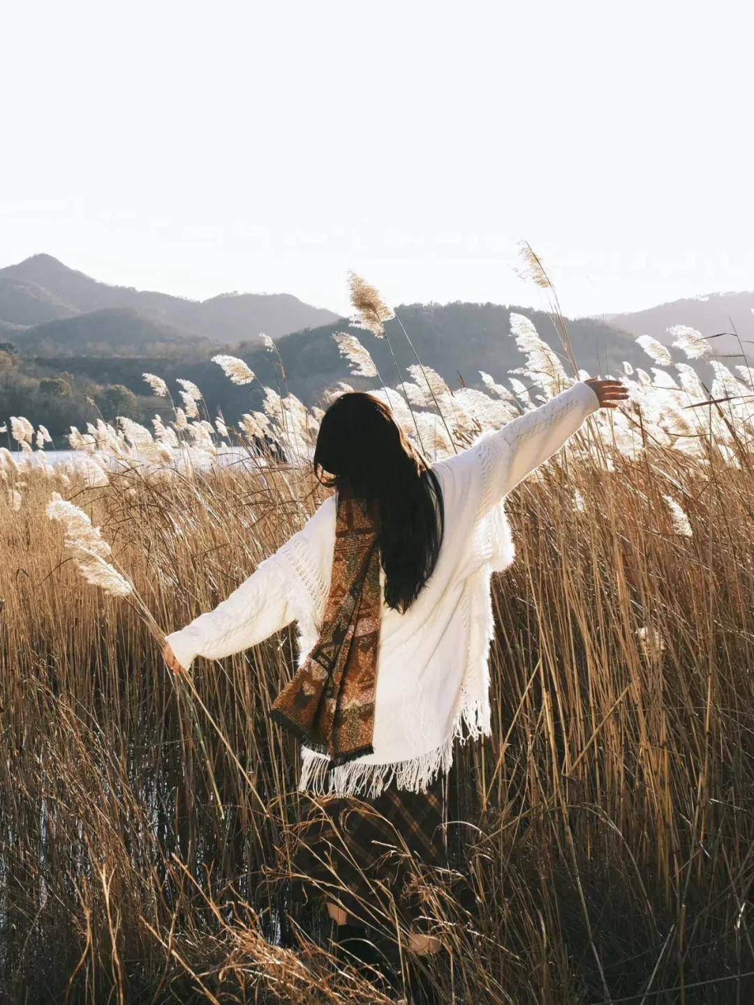 可以选择拉近距离去拍半身特写,让背后的芦苇填充画面,聚焦人物主体