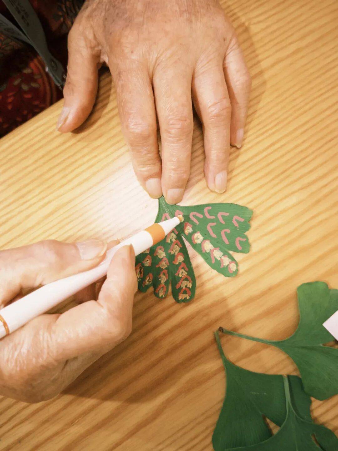在制作环节参与者们尽情挥洒想象力先是用马克笔在树叶和纸杯上勾勒