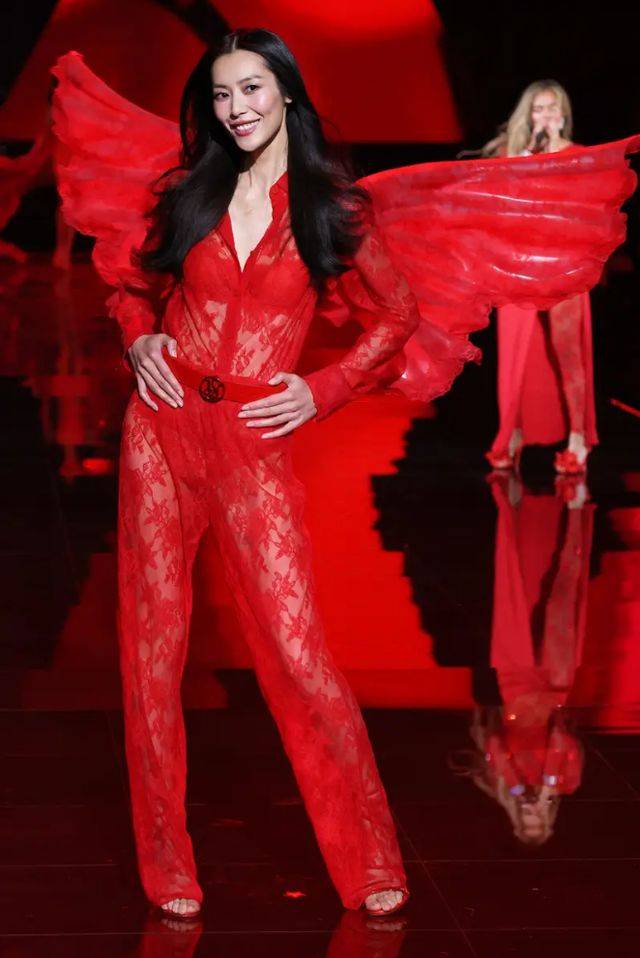在这套服装中,刘雯穿的是红色的内衣,搭配红色薄纱裙,肩上背着一对