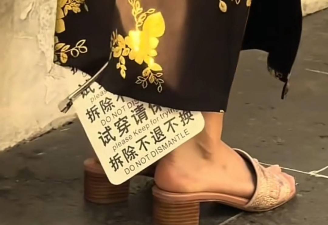女子穿带巨大吊牌旗袍街头拍照 商家无奈：防“穿完就退”
