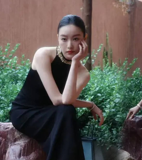 倪妮穿修身长裙身材曼妙，漫步雨中尽显故事感