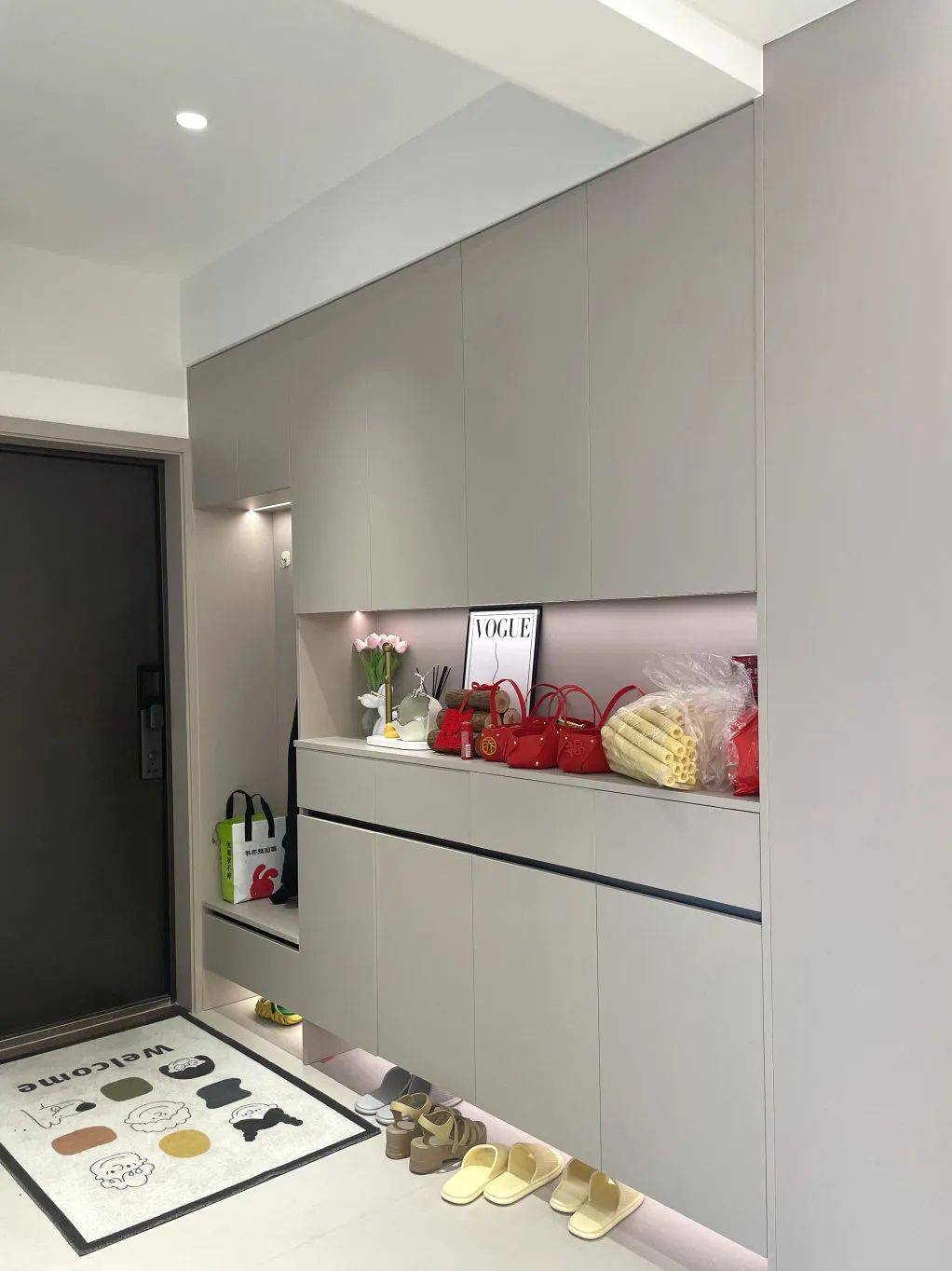 一门到顶的奶咖色饰柜,有趣的卡通门垫,精致的装饰摆件.
