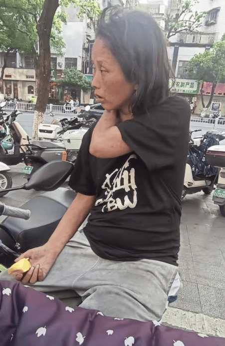 照片中流浪在街头的女子,虽然年轻却蓬头垢面,衣衫不整.