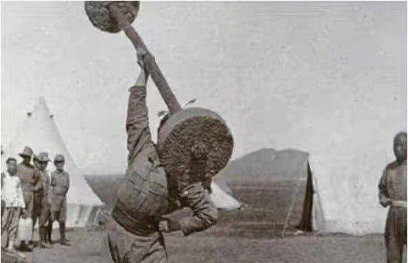 这最后一张照片拍摄的是清朝,一位大力士正在举像杠铃一样的东西