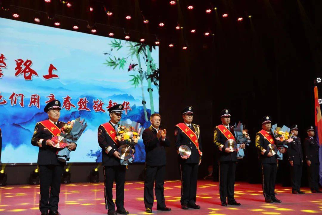 高继业同志为赵巴特尔等5位荣退民警代表颁奖,他们身披荣光,手捧鲜花