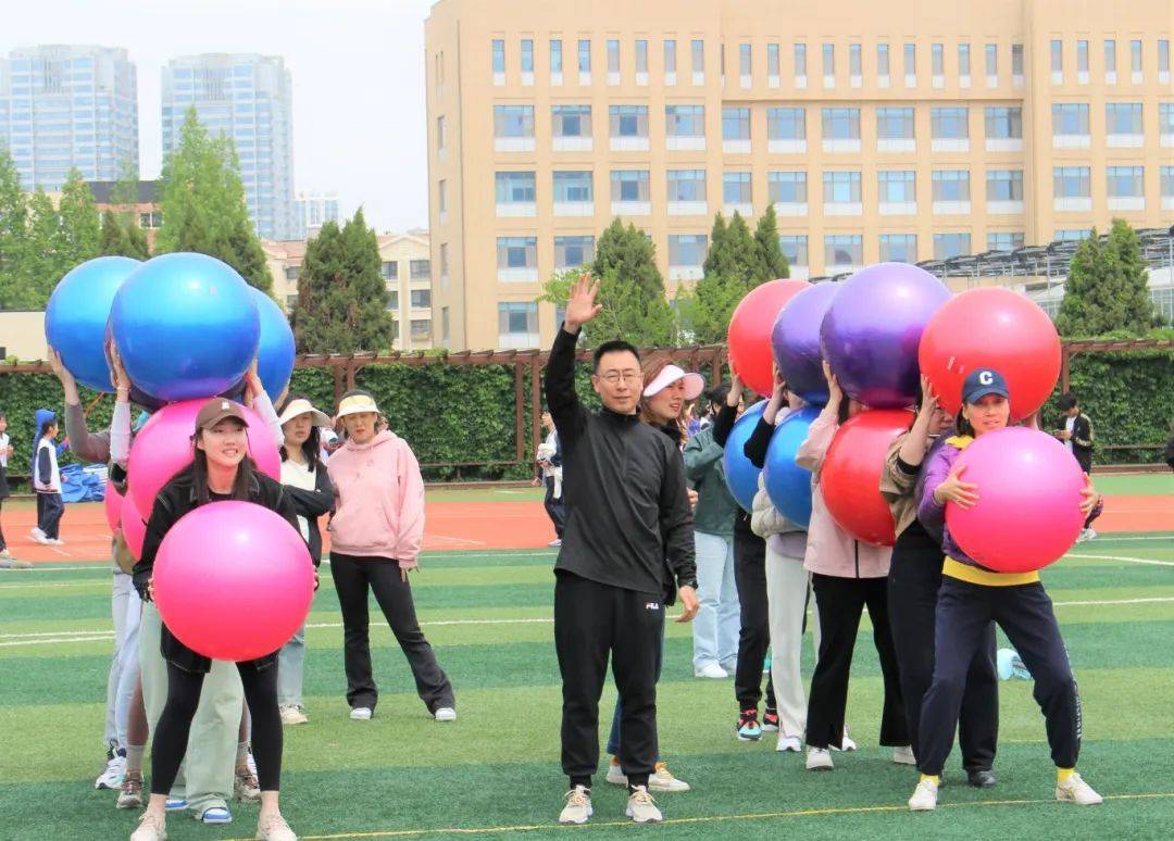 各工会组选派5人组成队伍参赛,每人双手高举一枚瑜伽球,五人相连胸背