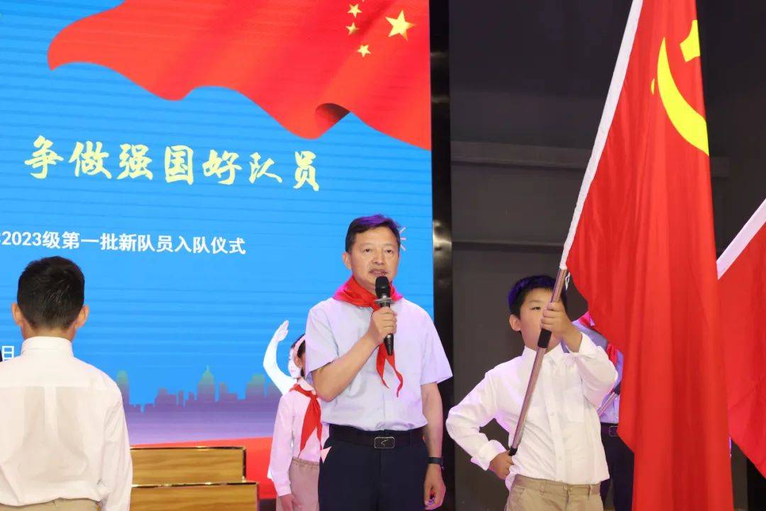 副校长韦云成等领导出席仪式,分别向新队员授予党旗,国旗,团旗和队旗