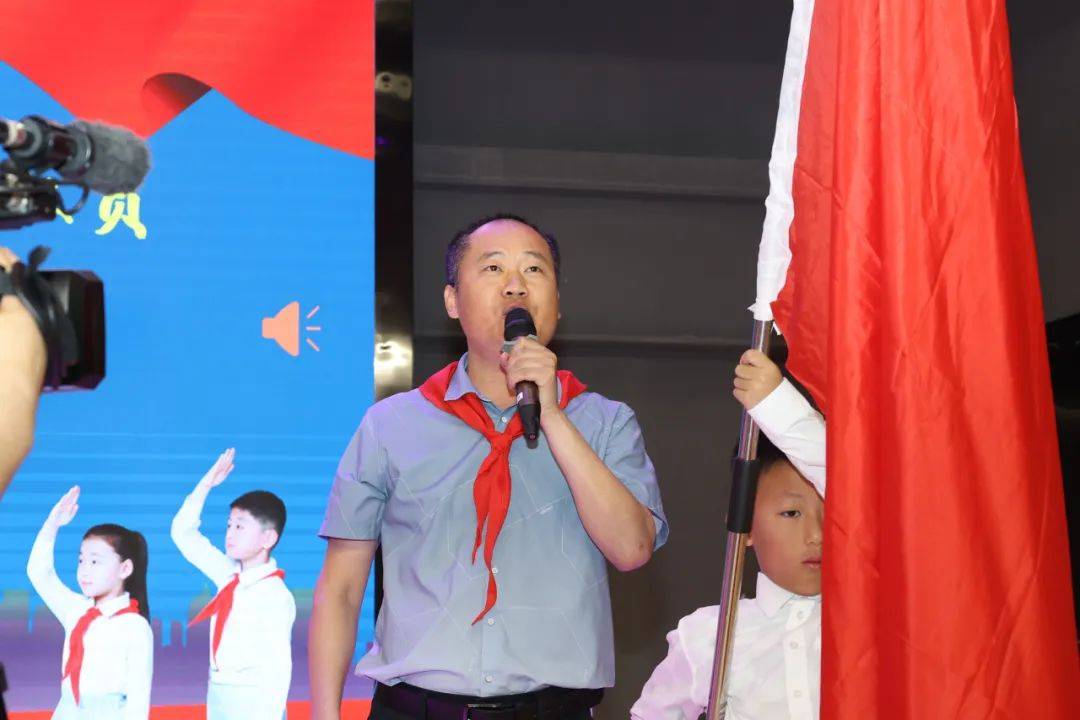 副校长韦云成等领导出席仪式,分别向新队员授予党旗,国旗,团旗和队旗