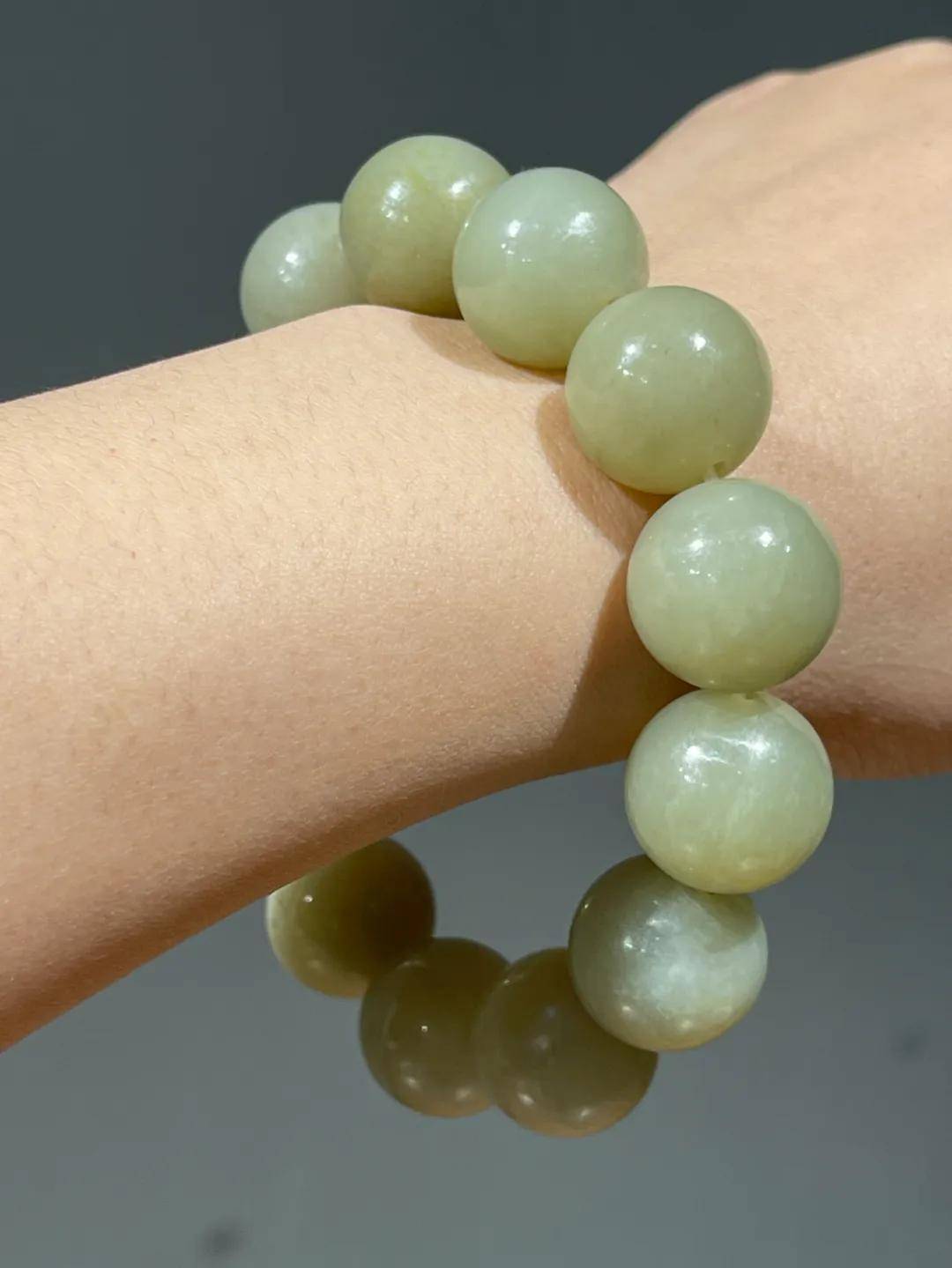 这是一组和田青黄玉大圆珠串成手链,和田青黄玉大珠共十三粒,圆珠尺寸