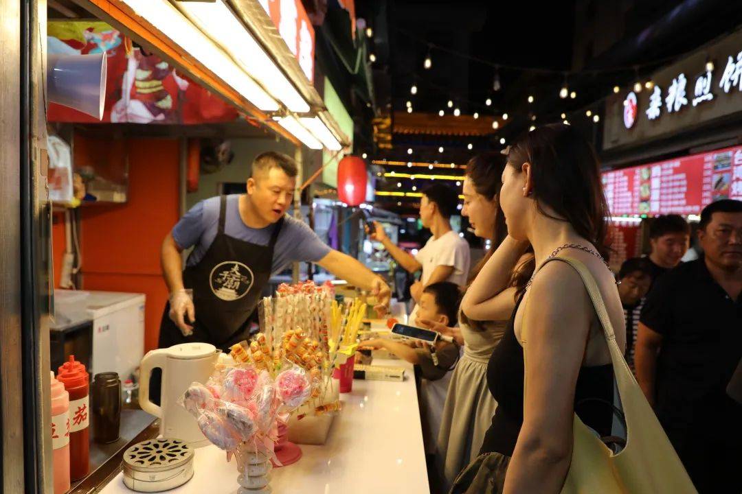 这里灯火璀璨,夜市上烤肉,关东煮,钵钵鸡,手打柠檬茶等特色美食小摊前