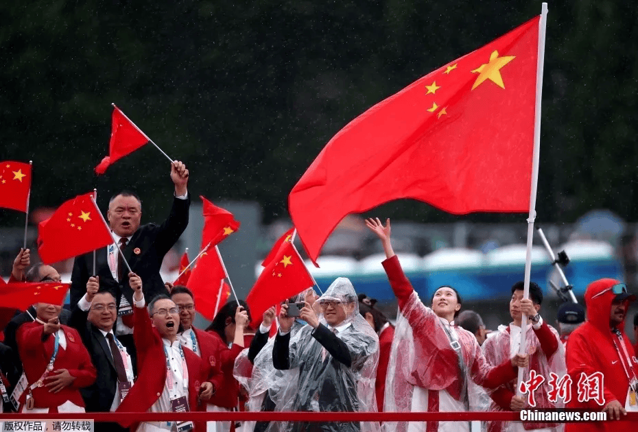 在开幕式前挥舞国旗乒乓球选手马龙(中)中国体育代表团旗手特罗卡德罗