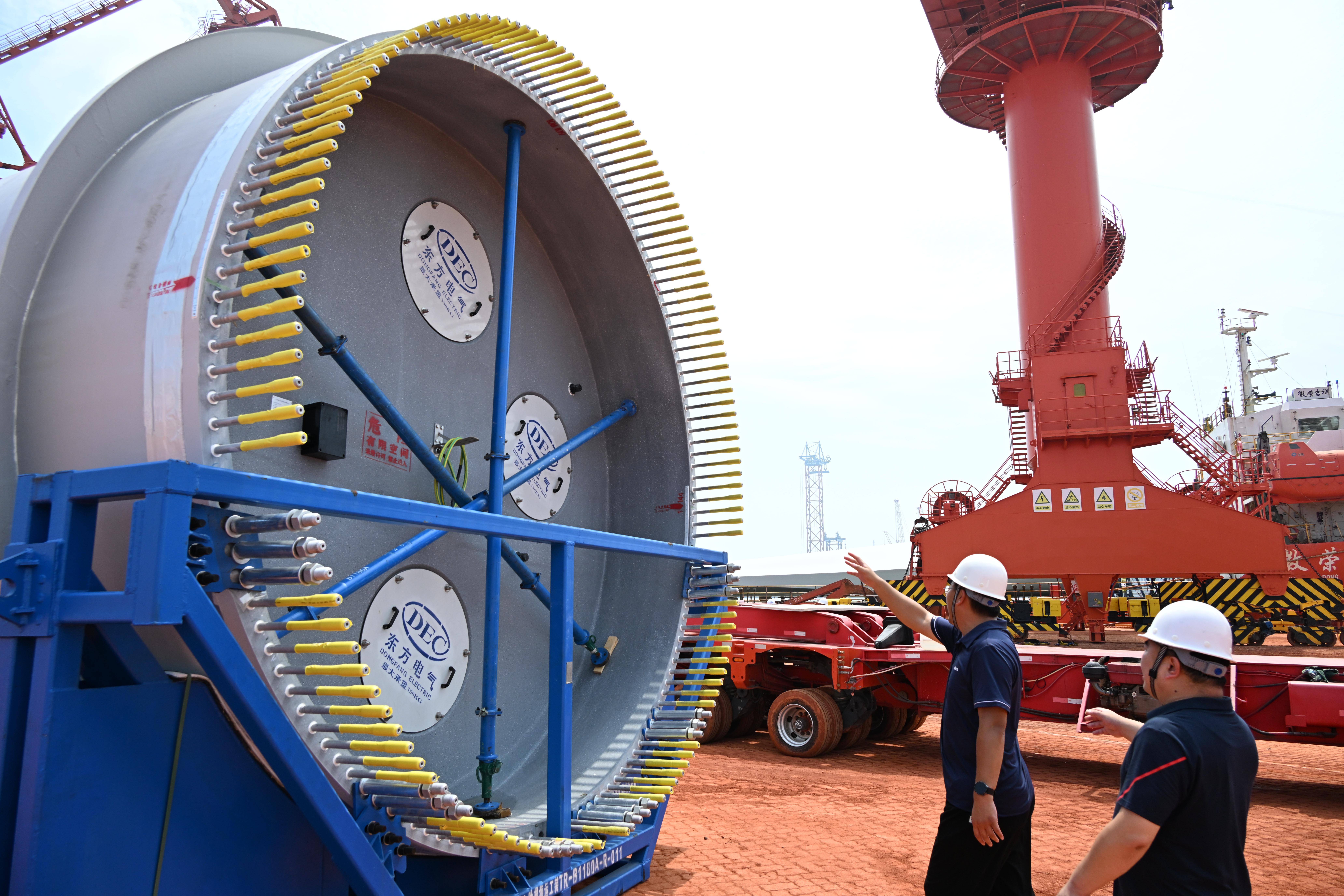 8月13日,山东港口烟台港蓬莱港公司码头,工作人员在查验即将吊装的风