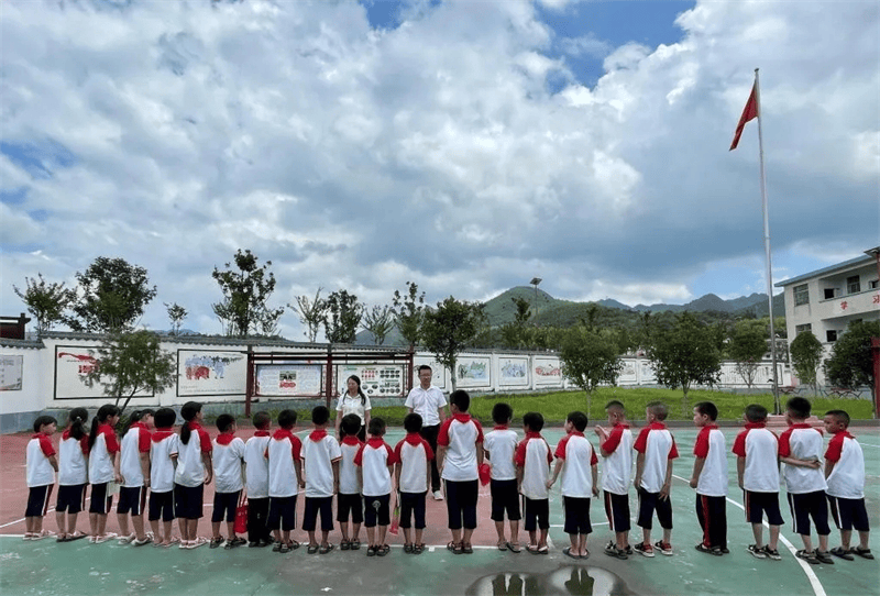 朱细芬(左),李亚东(右)在学校篮球场向来报到的学生交代新学期注意
