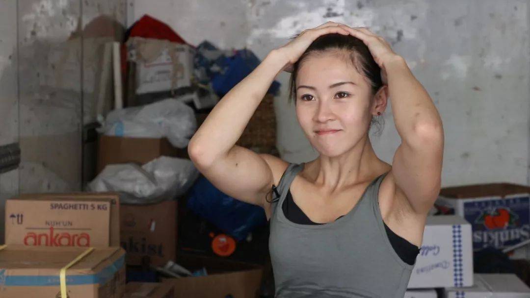 这么一位女搬运工,一袭白色短背心,灰色牛仔短裤,扛起货物时,露出一身