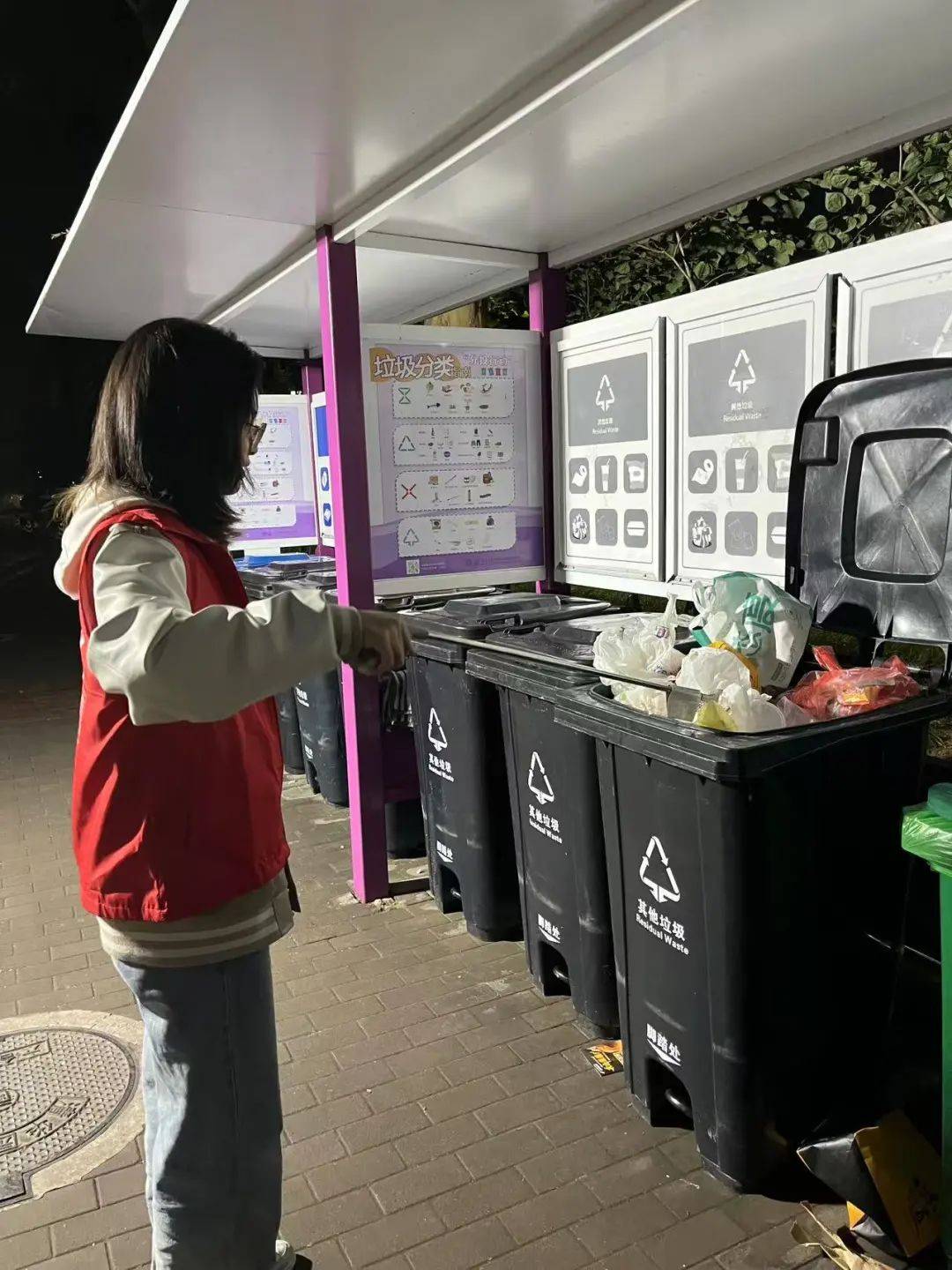 亮眼红色志愿服的同学们就齐刷刷上岗散布在各个宿舍楼下的垃圾桶边