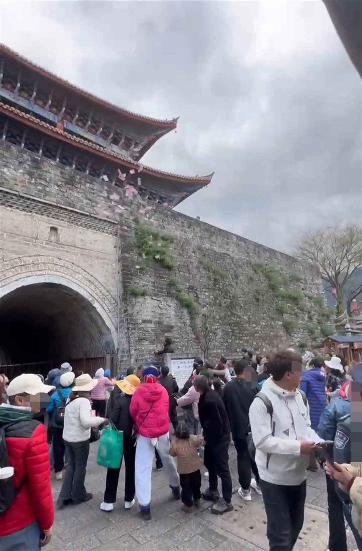 一老人在大理古城门上撒钱引游客争相捡拾,当地:系老人过激行为,暂未听说要求归还 一老人在大理古城门上撒钱引游客争相捡拾,当地:系老人过激行为,暂未听说要求归还